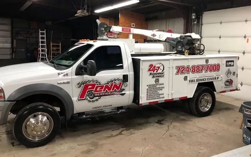 White tow truck with a crane in a garage. 