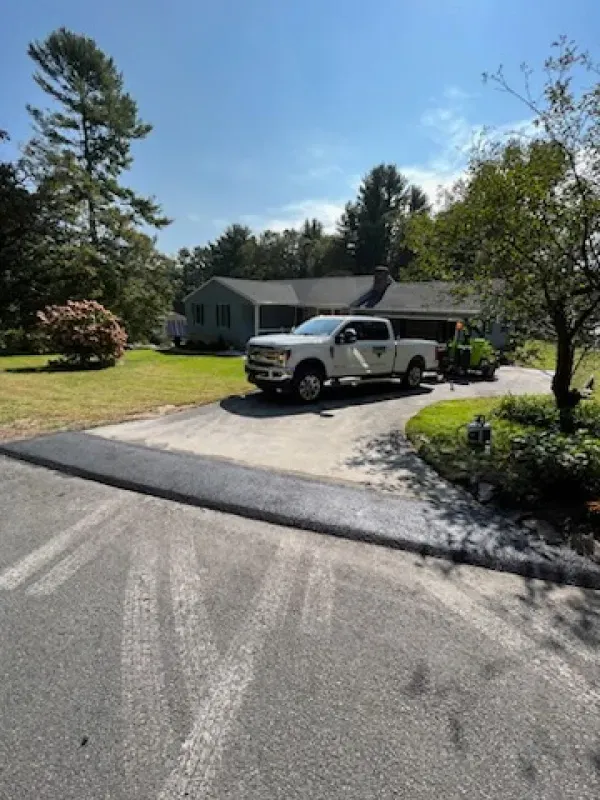 A white truck is parked in front of a house