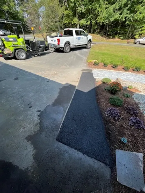 A white truck is parked in a driveway next to a green golf cart
