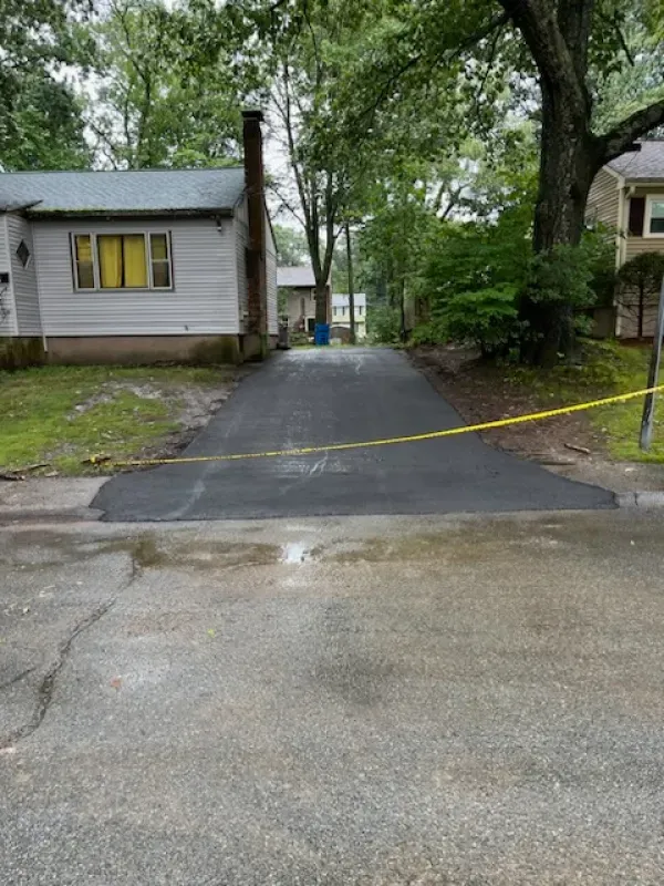 A driveway leading to a house with a yellow tape covering it