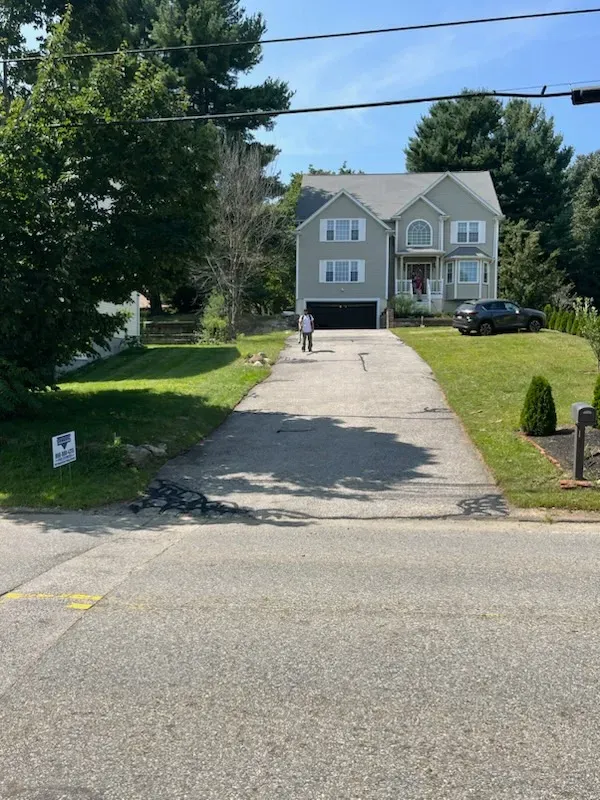 A driveway leading to a house with a sign that says ' i love you ' on it