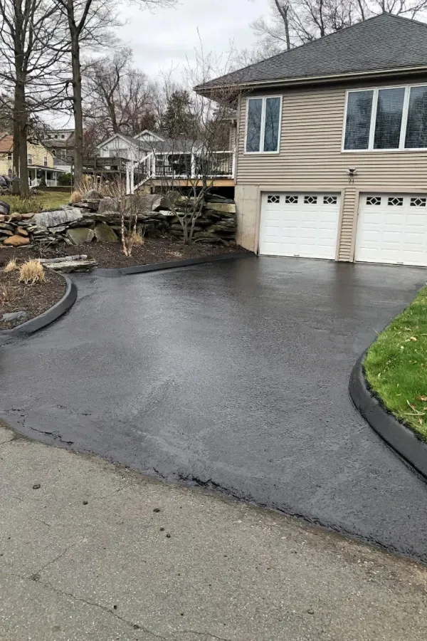 A driveway leading to a house with two garage doors