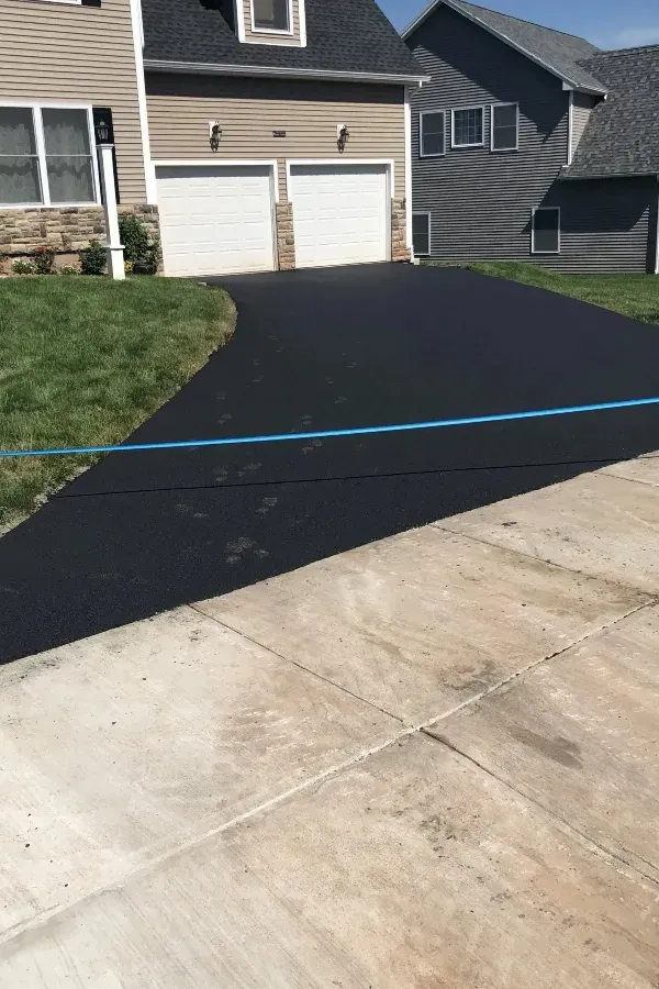A driveway is being paved in front of a house