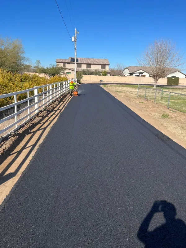A shadow of a person taking a picture of a road
