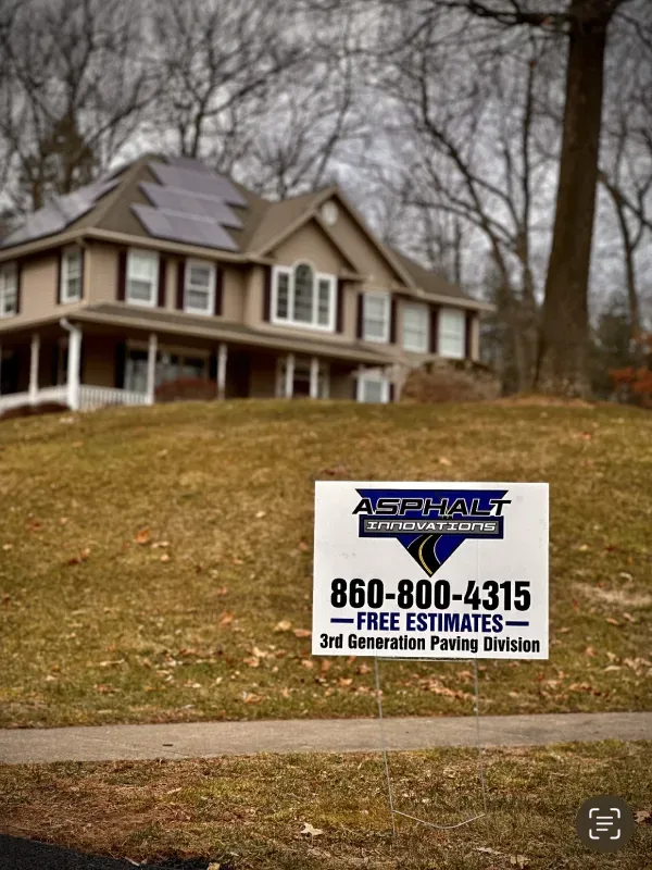 A house with a sign in front of it that says asphalt