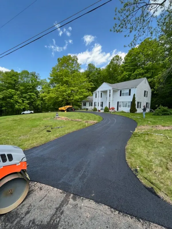 A driveway is being paved in front of a house