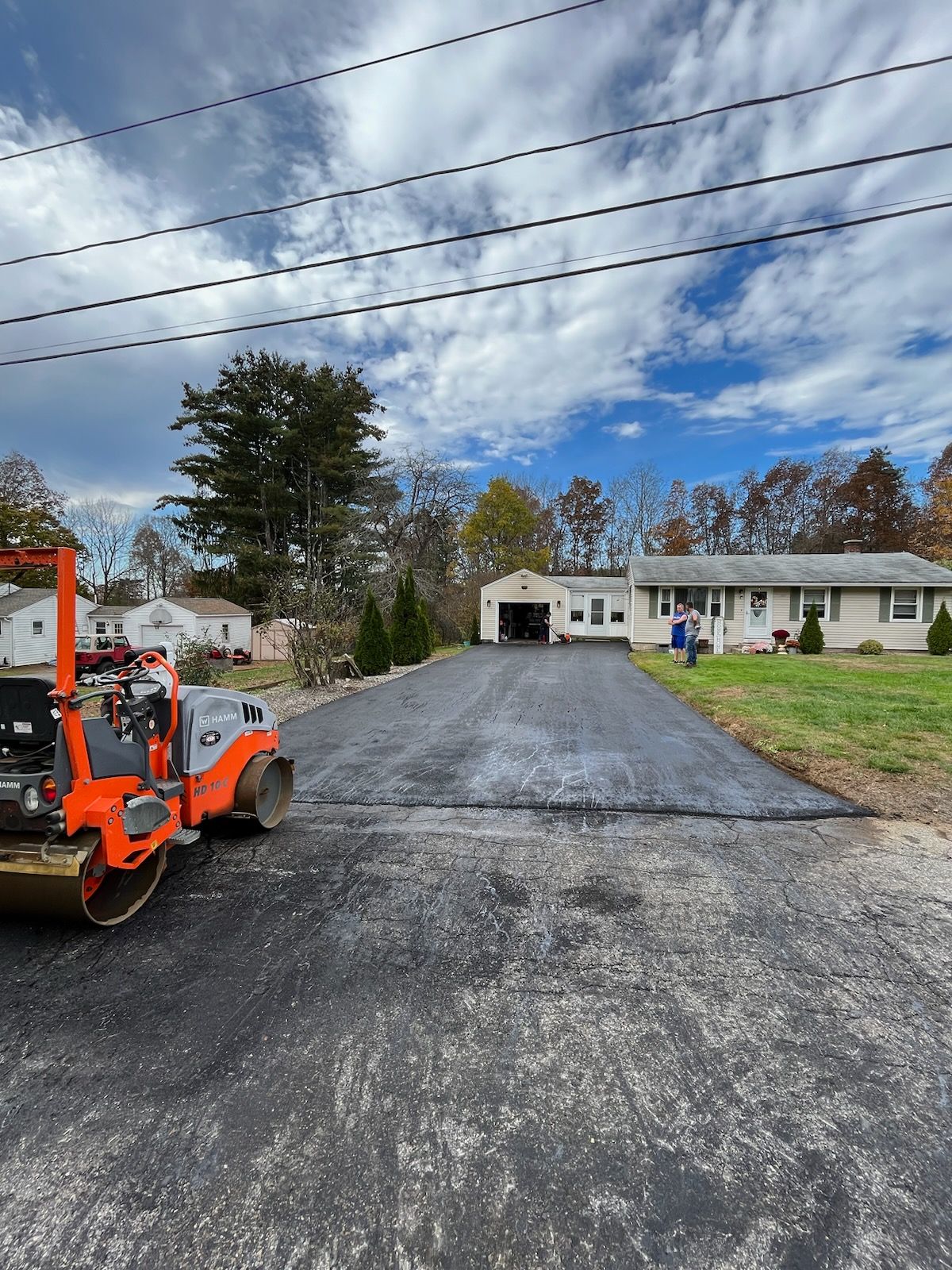 A machine is sitting on the side of a road in front of a house