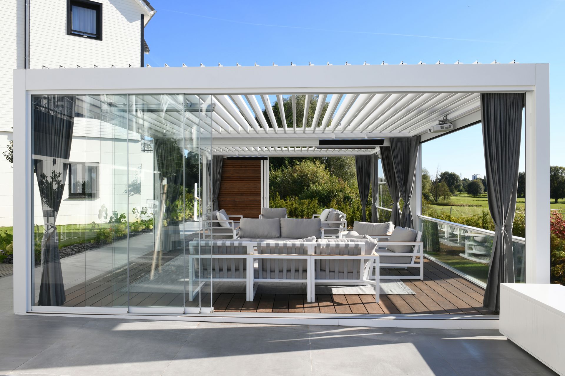 A patio with a pergola and sliding glass doors.