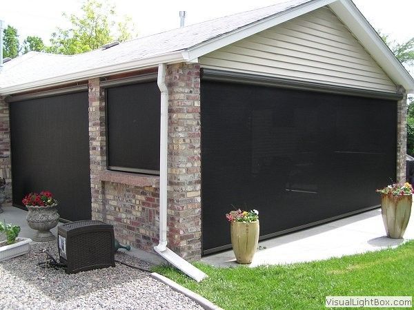 a house with a shade in porch and a shade in garage