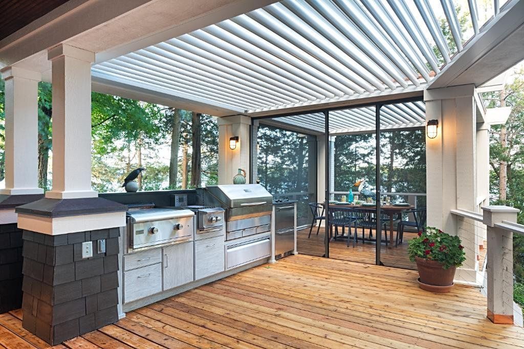 a large outdoor kitchen with a pergola and sliding glass doors