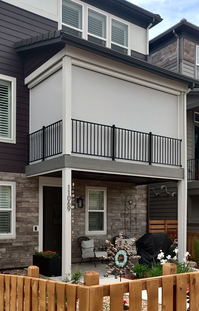 a house with a balcony and a wooden fence in front of it
