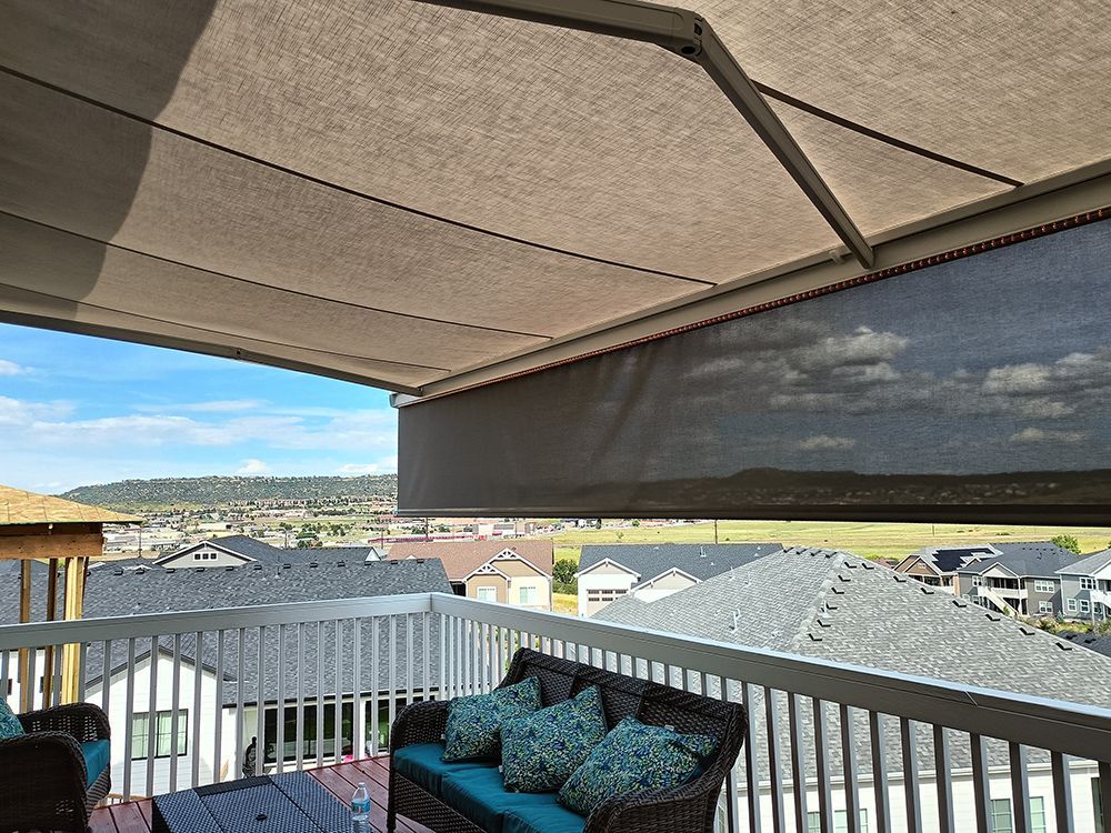 a balcony with a couch and a table under an awning