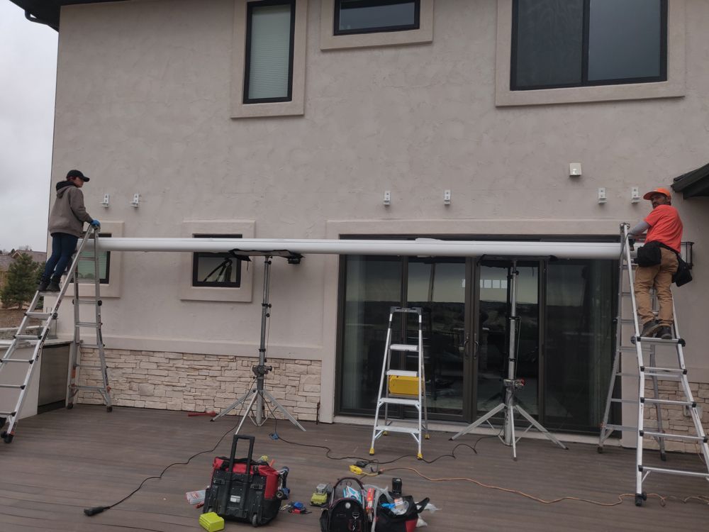a man is standing on a ladder in front of a house