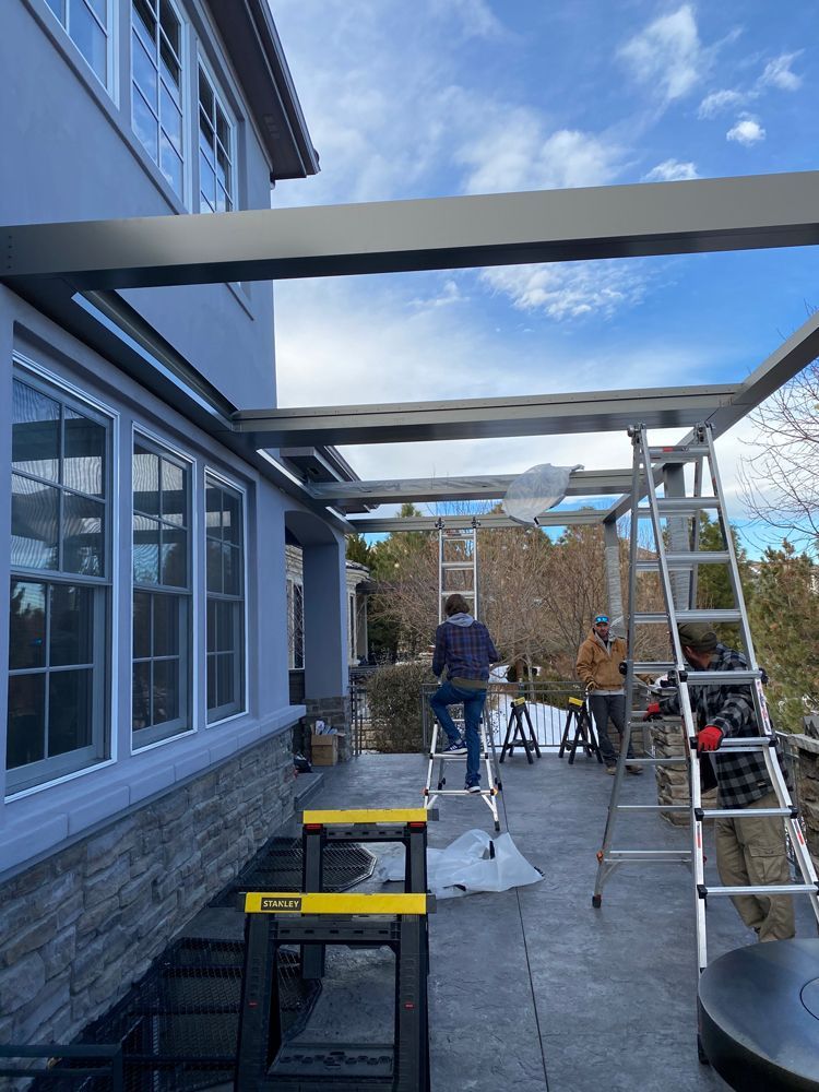 a man is sitting on a ladder in front of a house