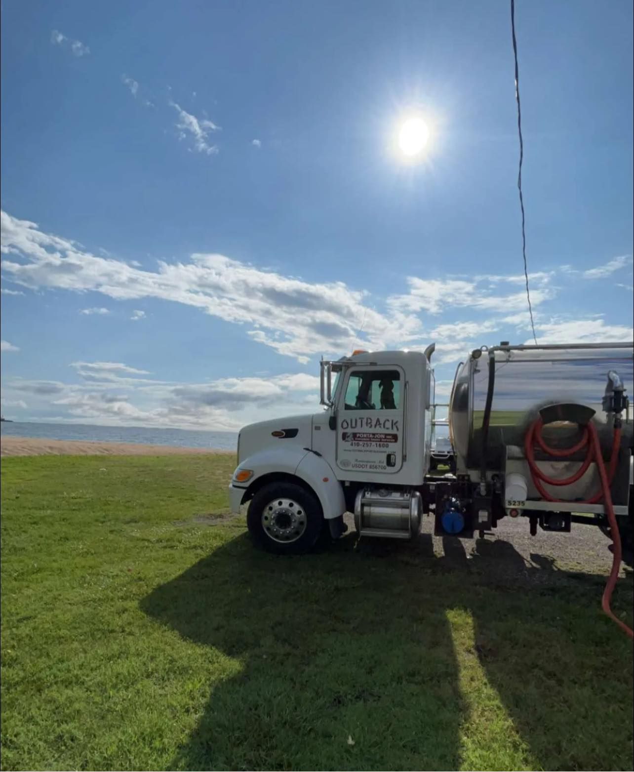 a large tanker truck is parked in a grassy field