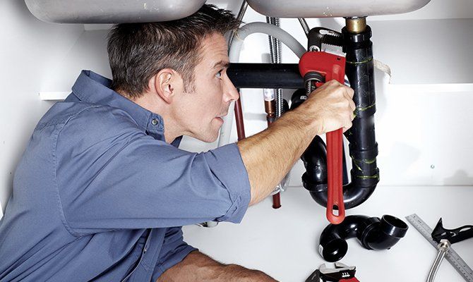 A plumber fixing sink pipe