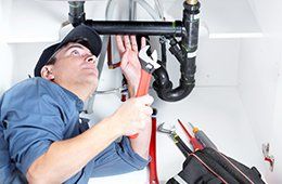 A plumber fixing sink pipe