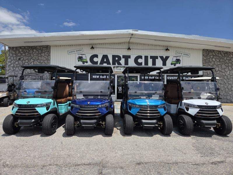 Four parked golf carts in front of a Cart City dealership building