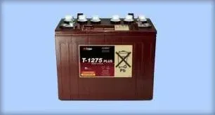 Brown industrial battery with six terminals and hazard labels on a blue background