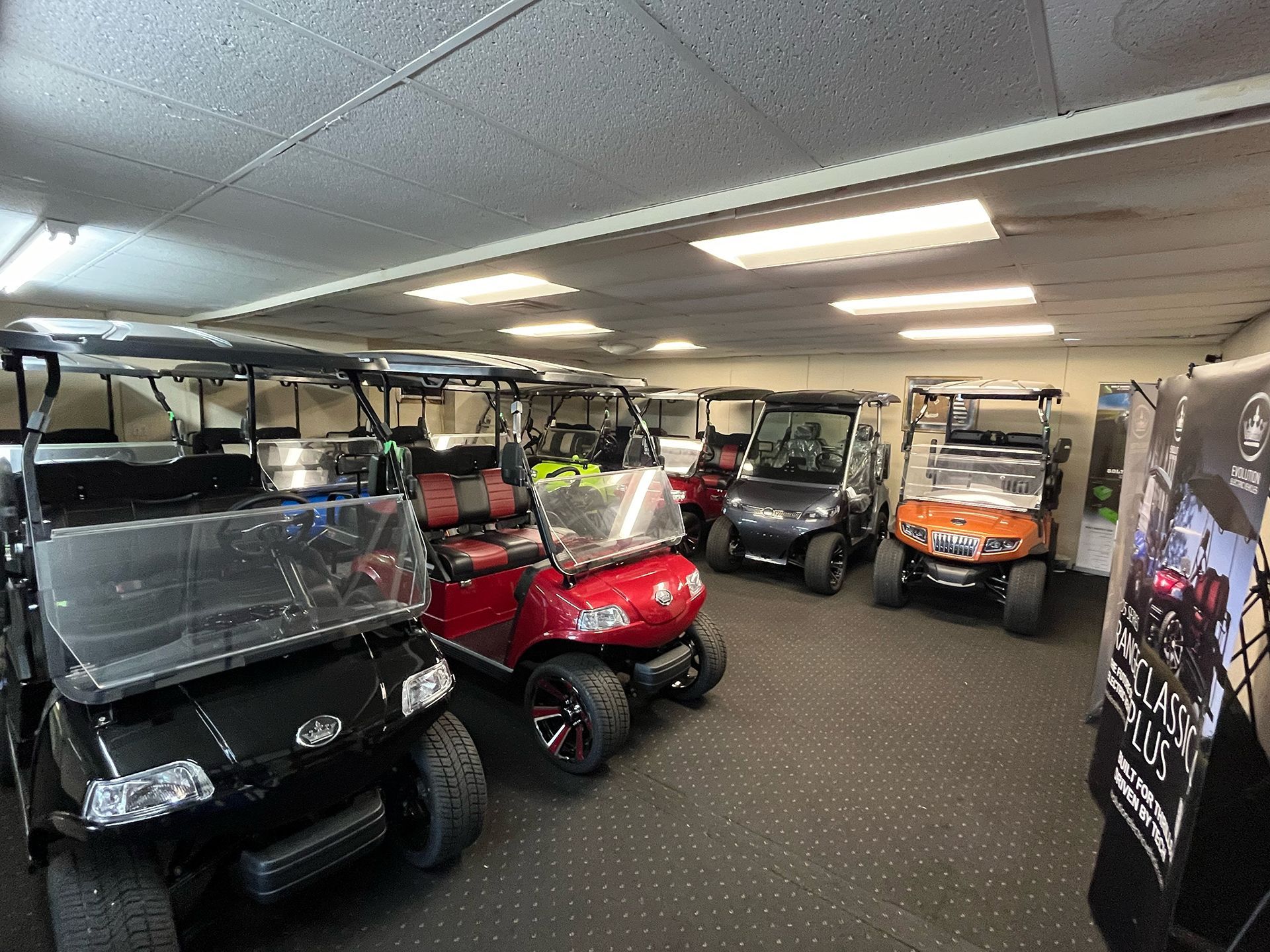 A bunch of golf carts are in a room
