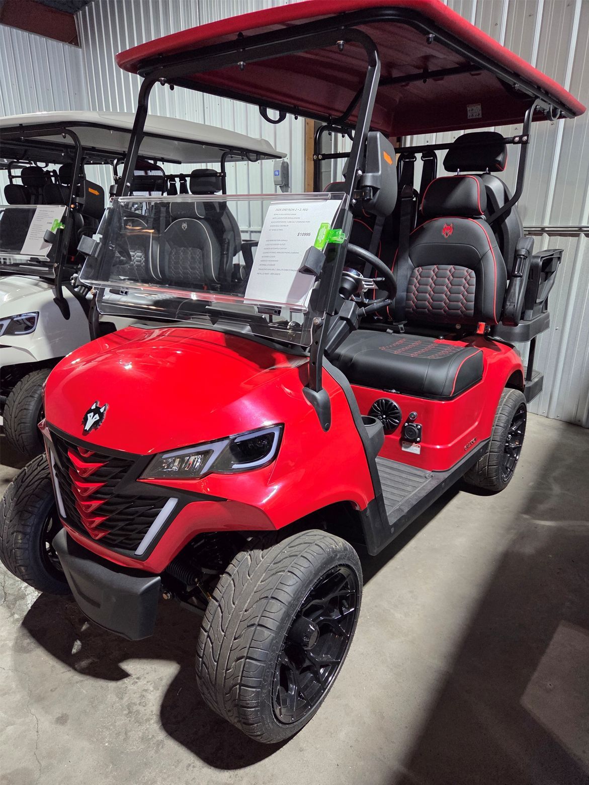 Red off-road utility cart with canopy, parked indoors