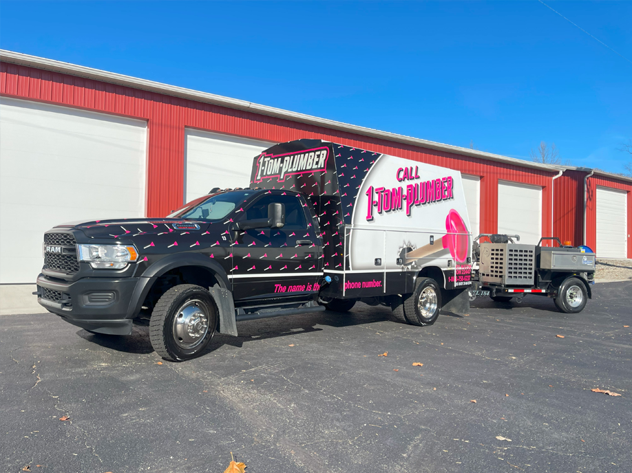 A truck with a trailer attached to it is parked in front of a building.