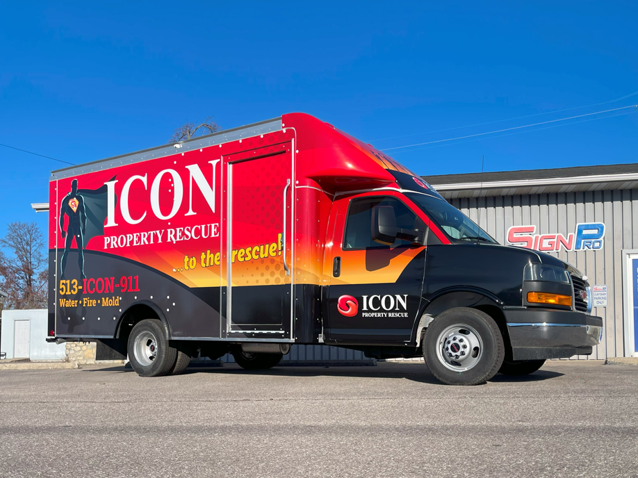 An Icon Property Rescue truck is parked in front of a building