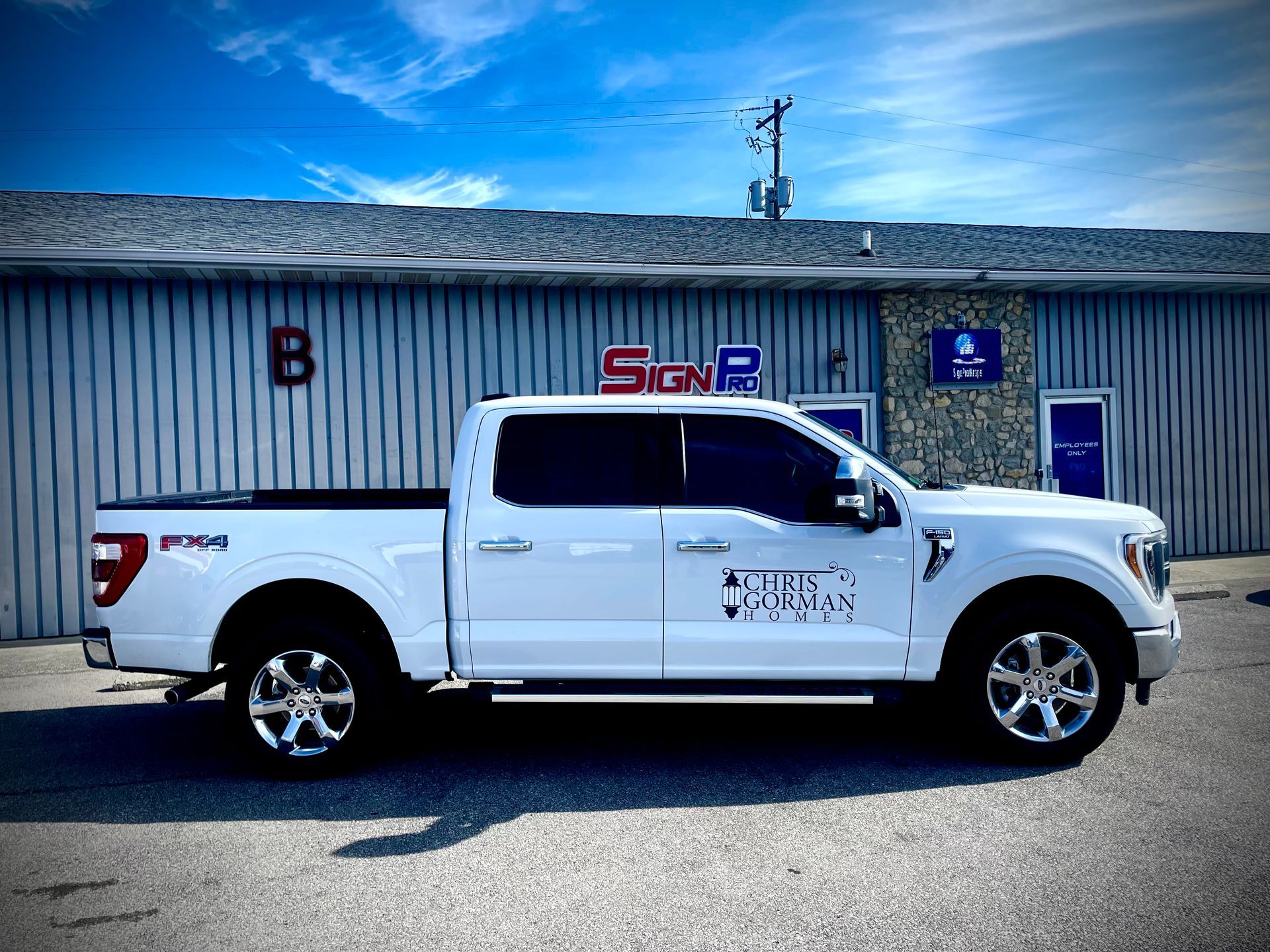 A white truck is parked in front of a building.