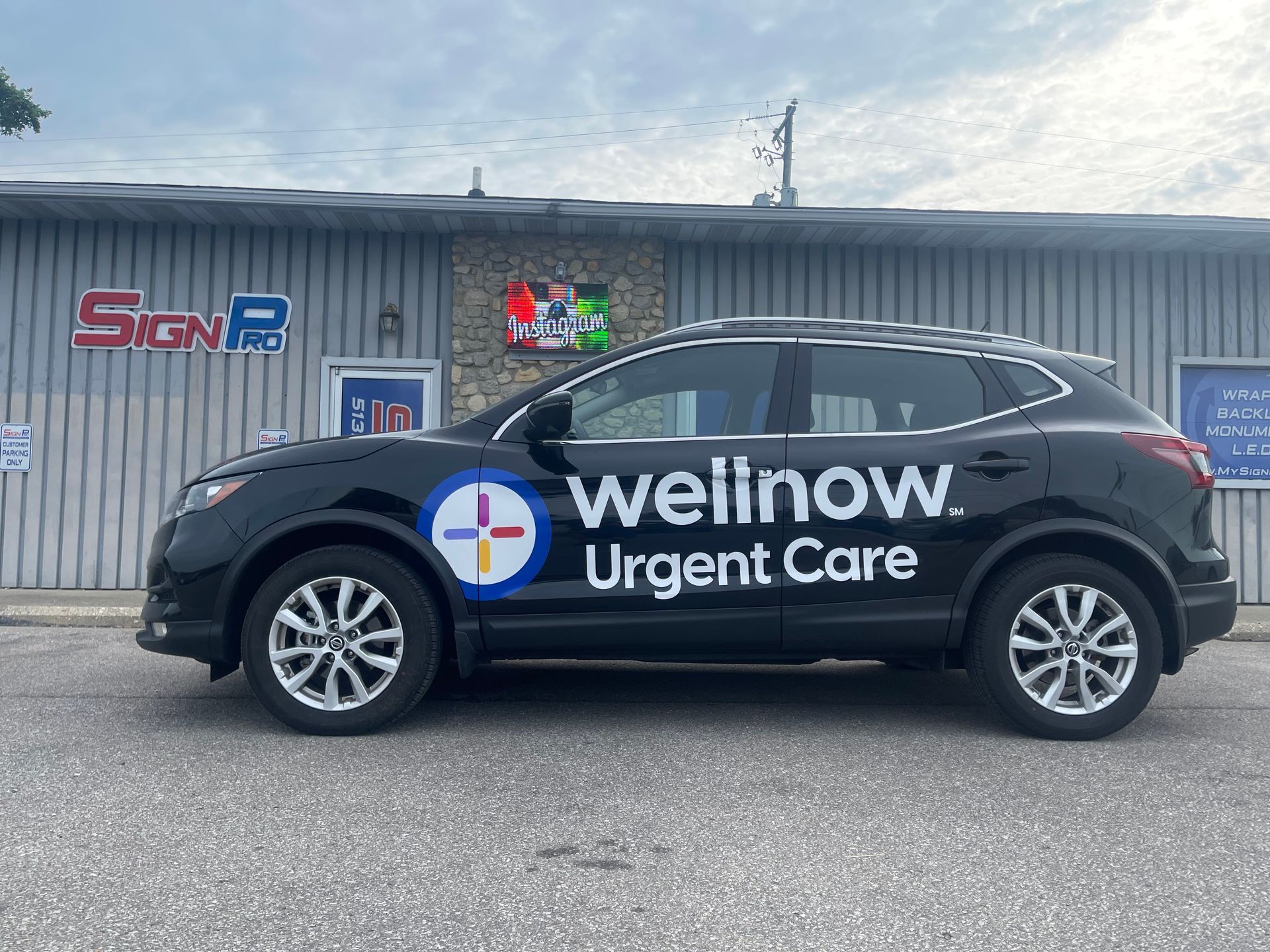 A wellnow urgent care car is parked in front of a building.