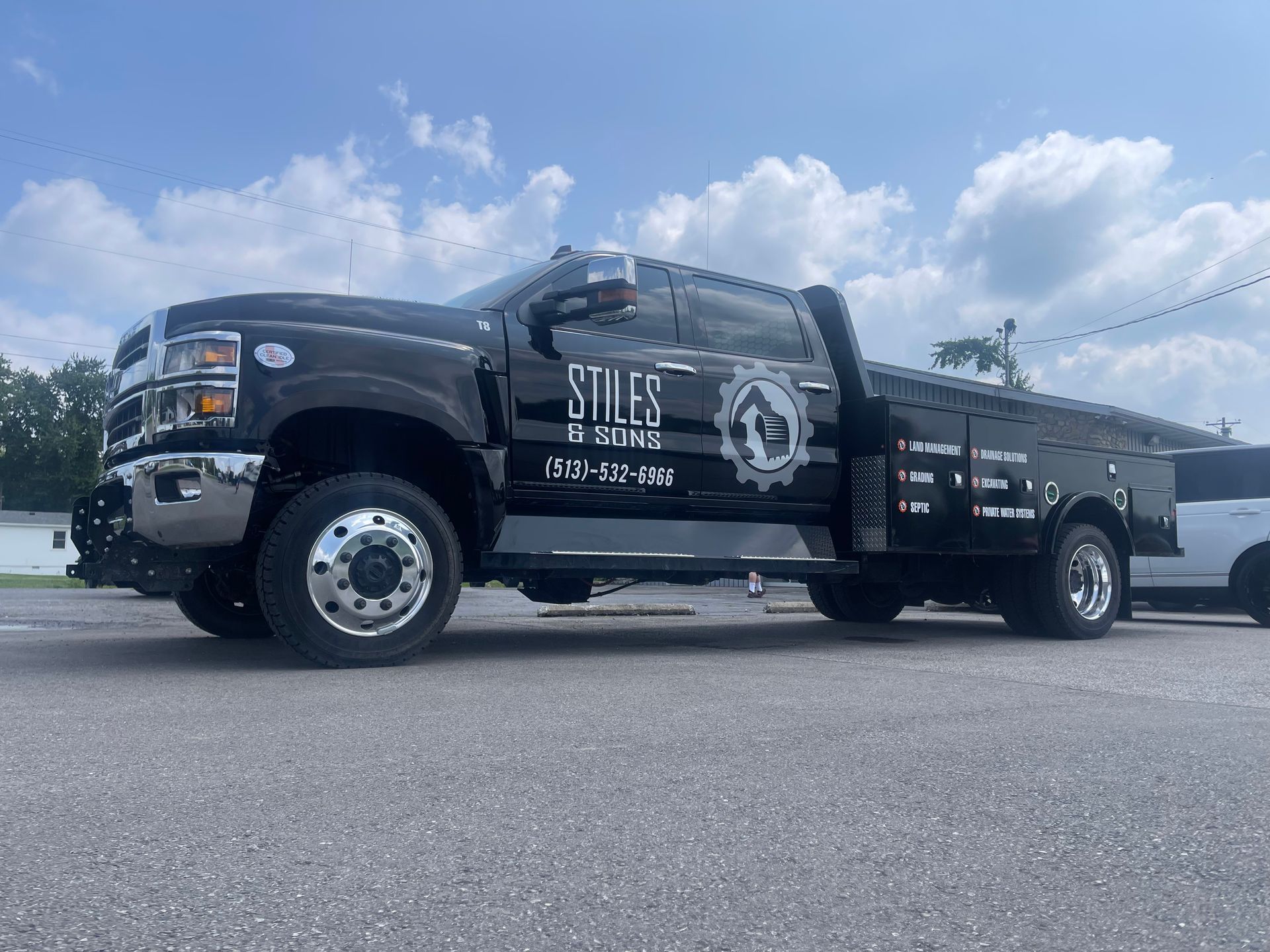 A black tow truck is parked in a parking lot.