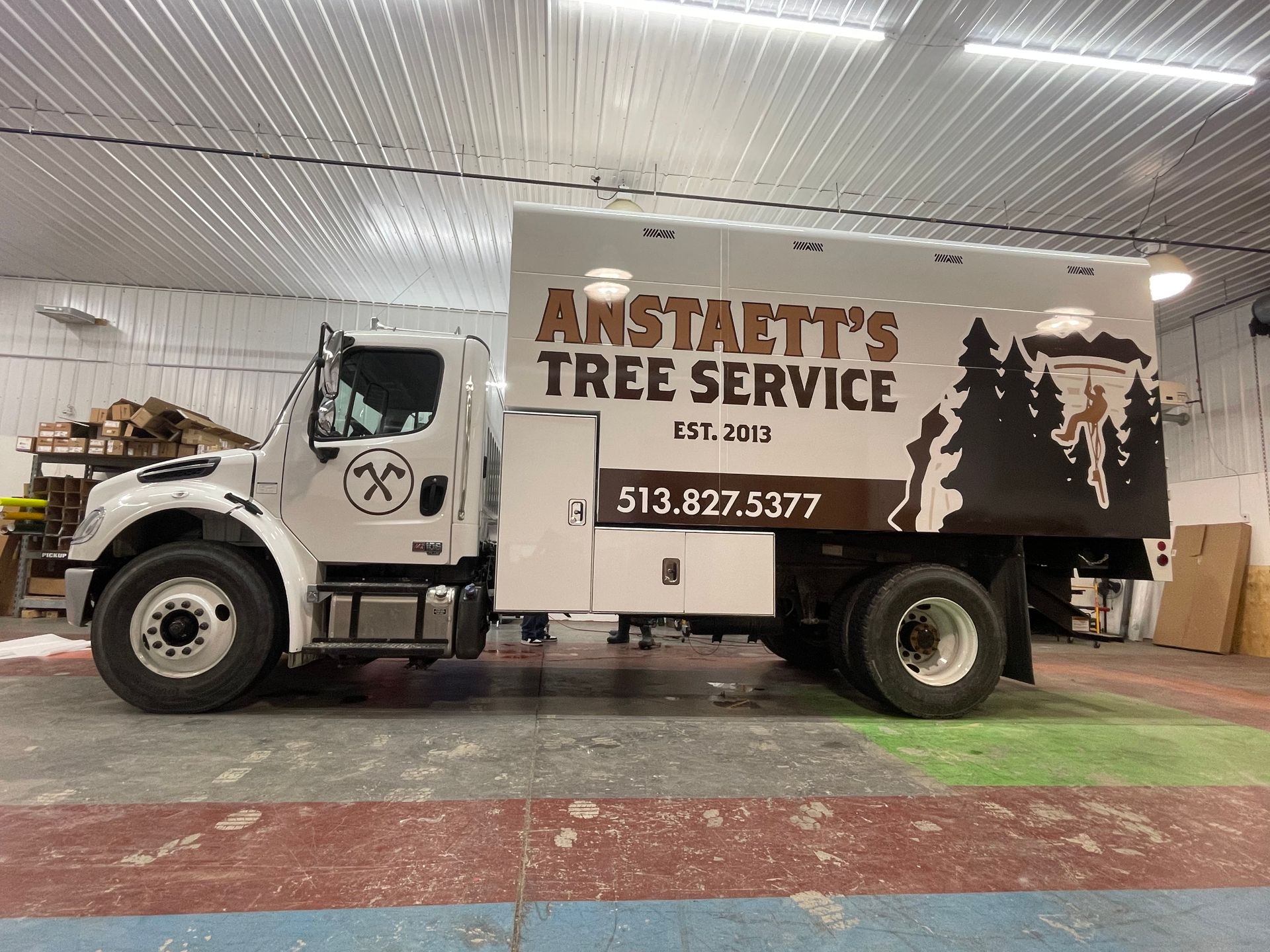 A tree service truck is parked in a garage.
