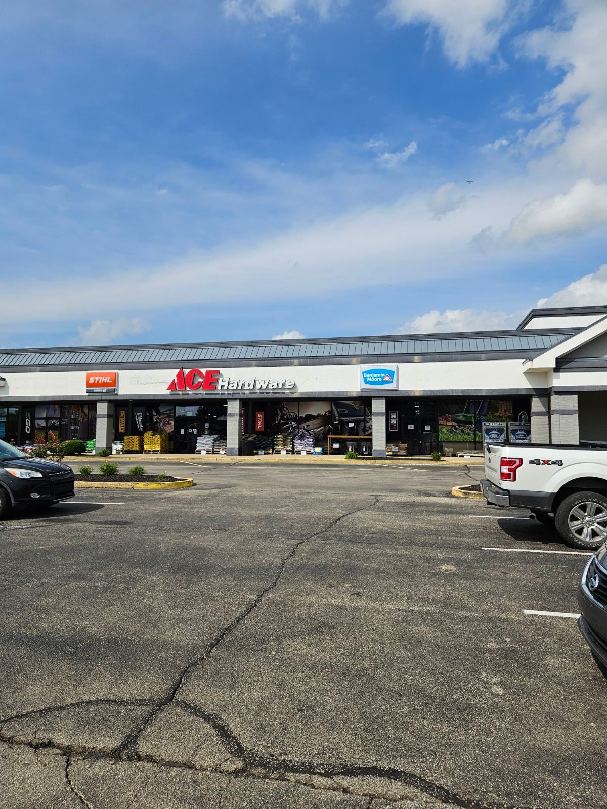 A white truck is parked in front of a store.