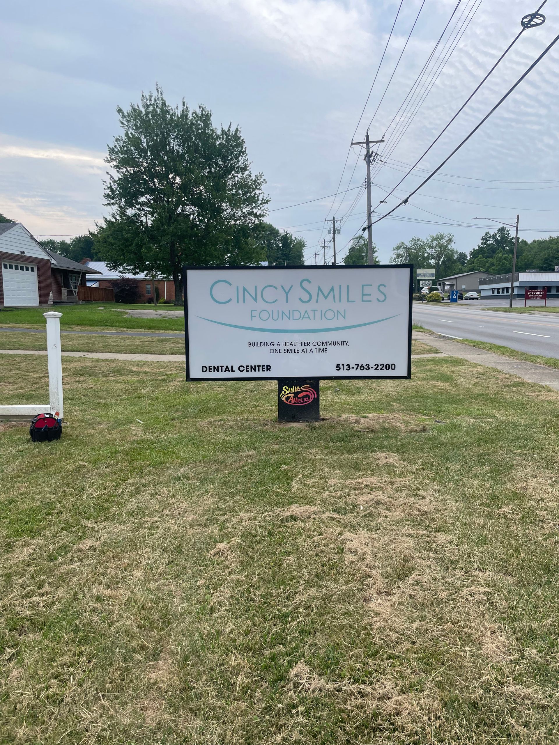 A large sign is sitting in the middle of a grassy field.