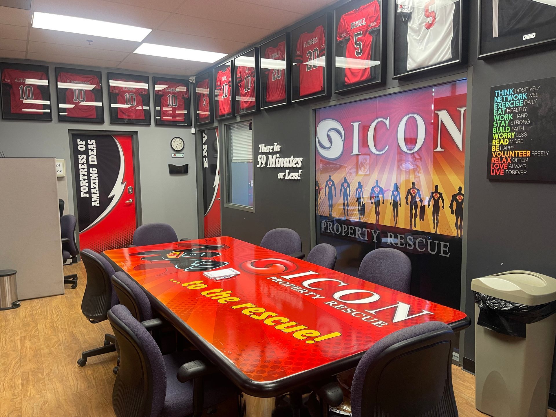 A conference room with a red table and chairs and a sign that says icon