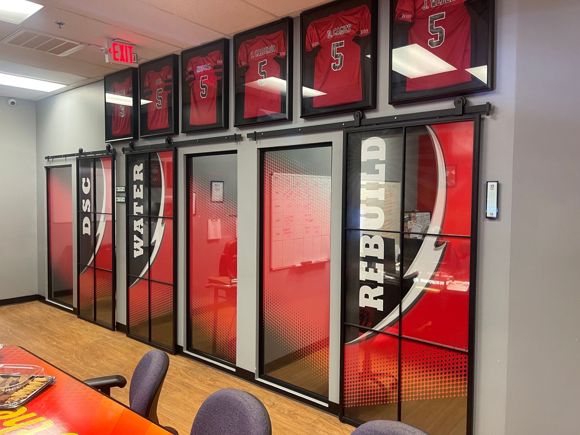 A conference room with a table and chairs and a row of sliding glass doors.