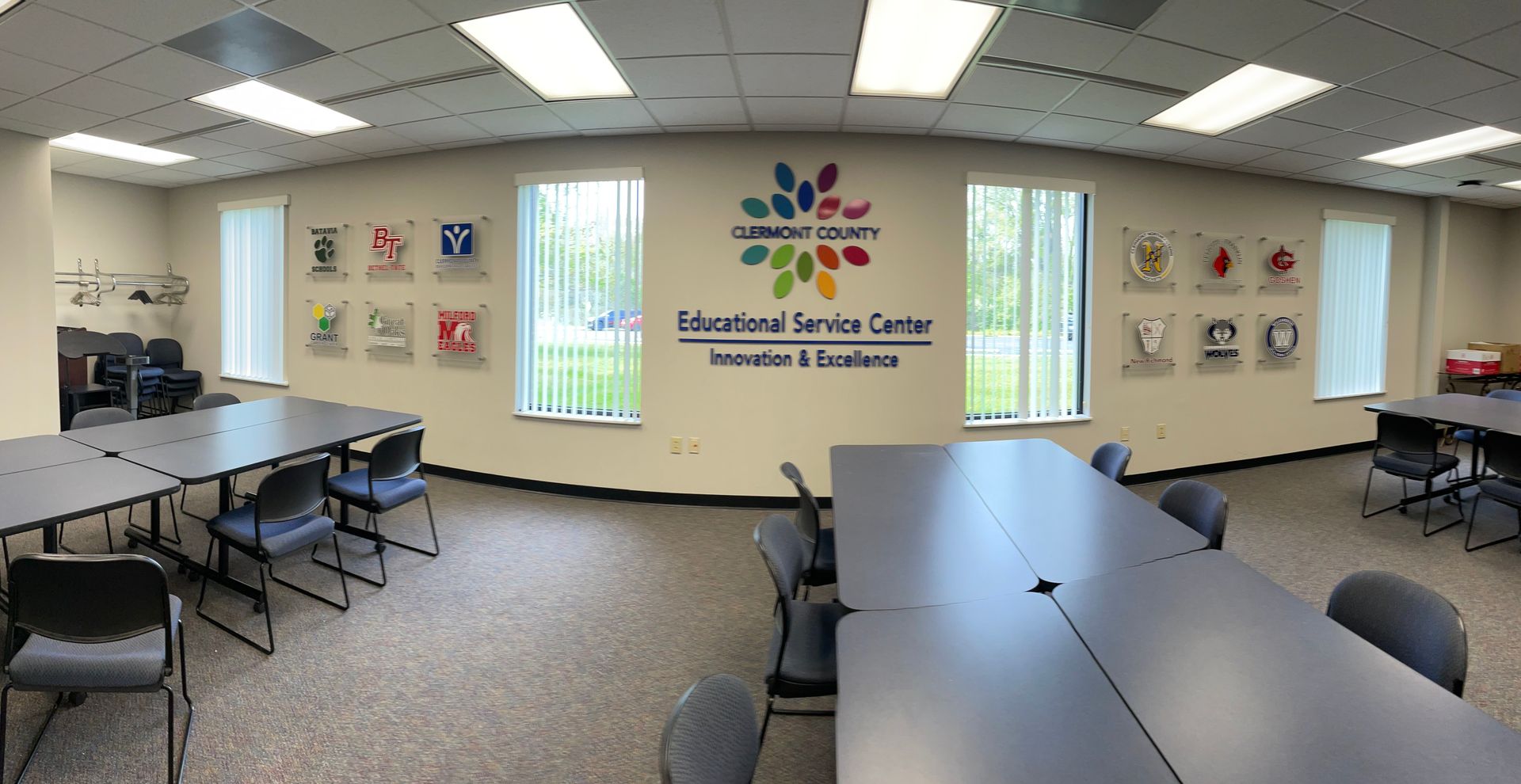A large room with tables and chairs, and a wall that says educational service center