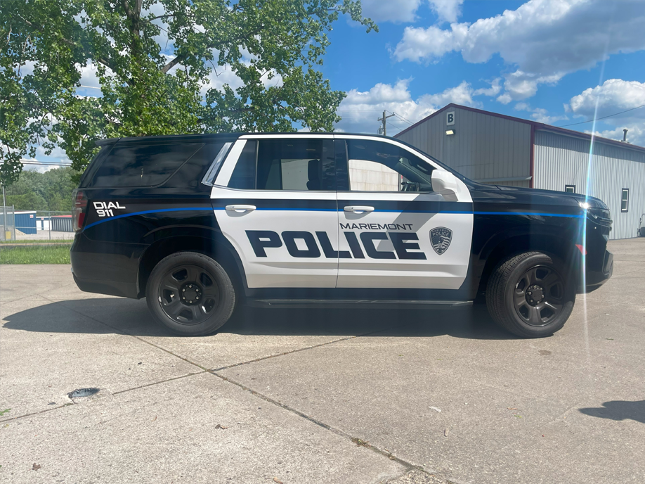 A black and white police car is parked on the side of the road.