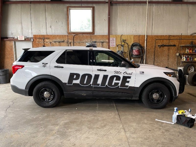 A white police car is parked in a garage.