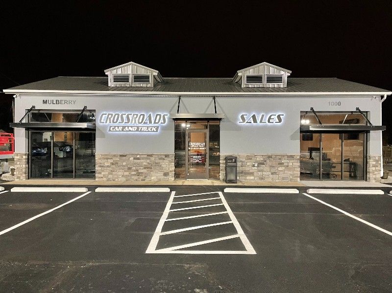 A large building with a lot of windows and a parking lot in front of it.