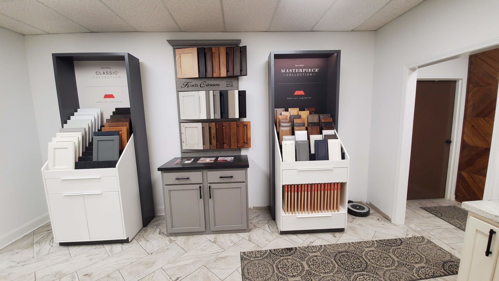 Cabinetry samples in a showroom; various wood tones, neutral colors, and styles displayed.