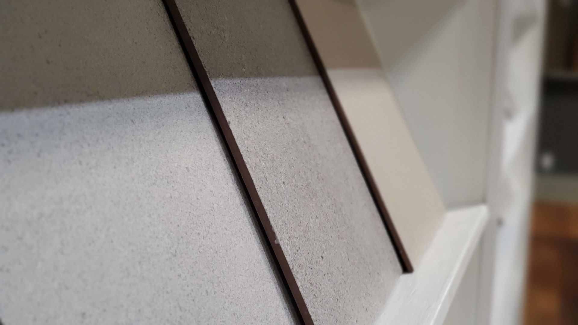 Close-up of three painted wall samples with dark brown trim.