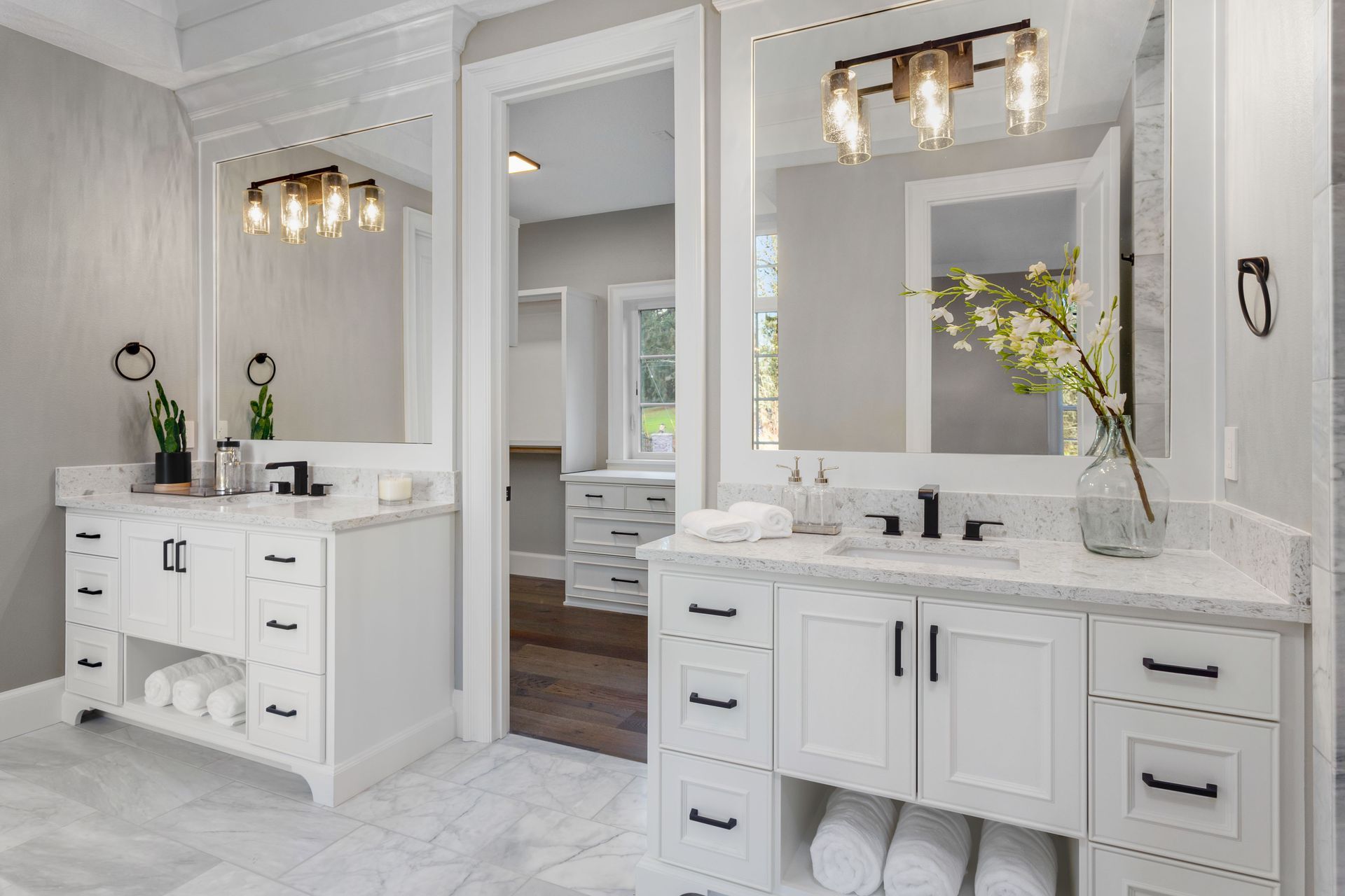 Bathroom with gray marble walls and black marble floor; window on right.