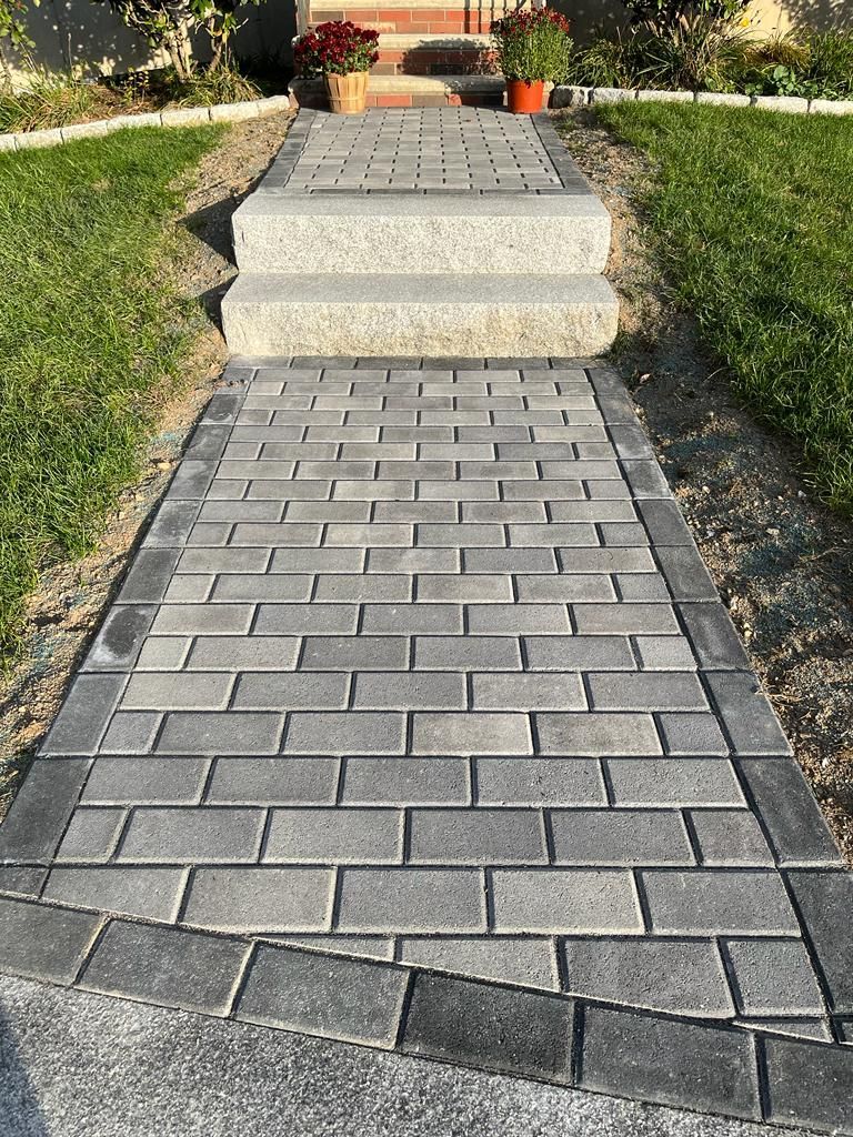 a brick walkway with stairs leading up to a house.