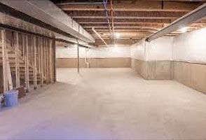Empty basement with concrete floor, exposed beams, and unfinished walls.