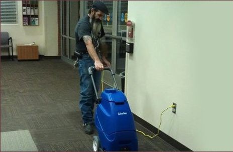 Man cleaning the carpet with a vacuum