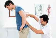 Male physiotherapist examining mans back