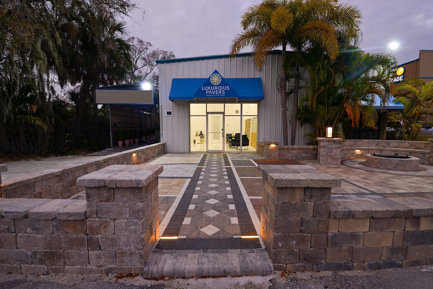 A building with a blue awning and a walkway leading to it.