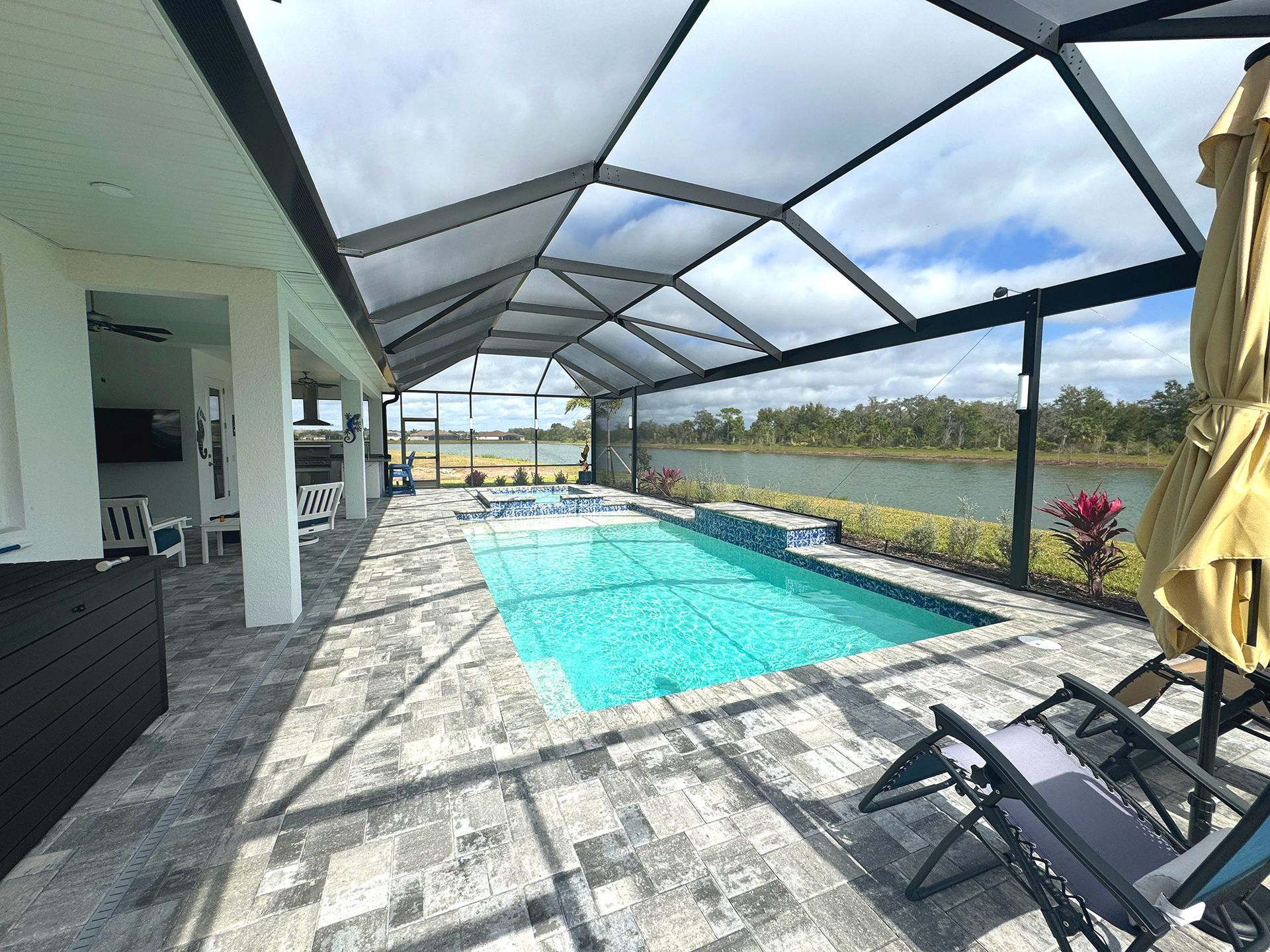 A large swimming pool is surrounded by chairs and umbrellas.
