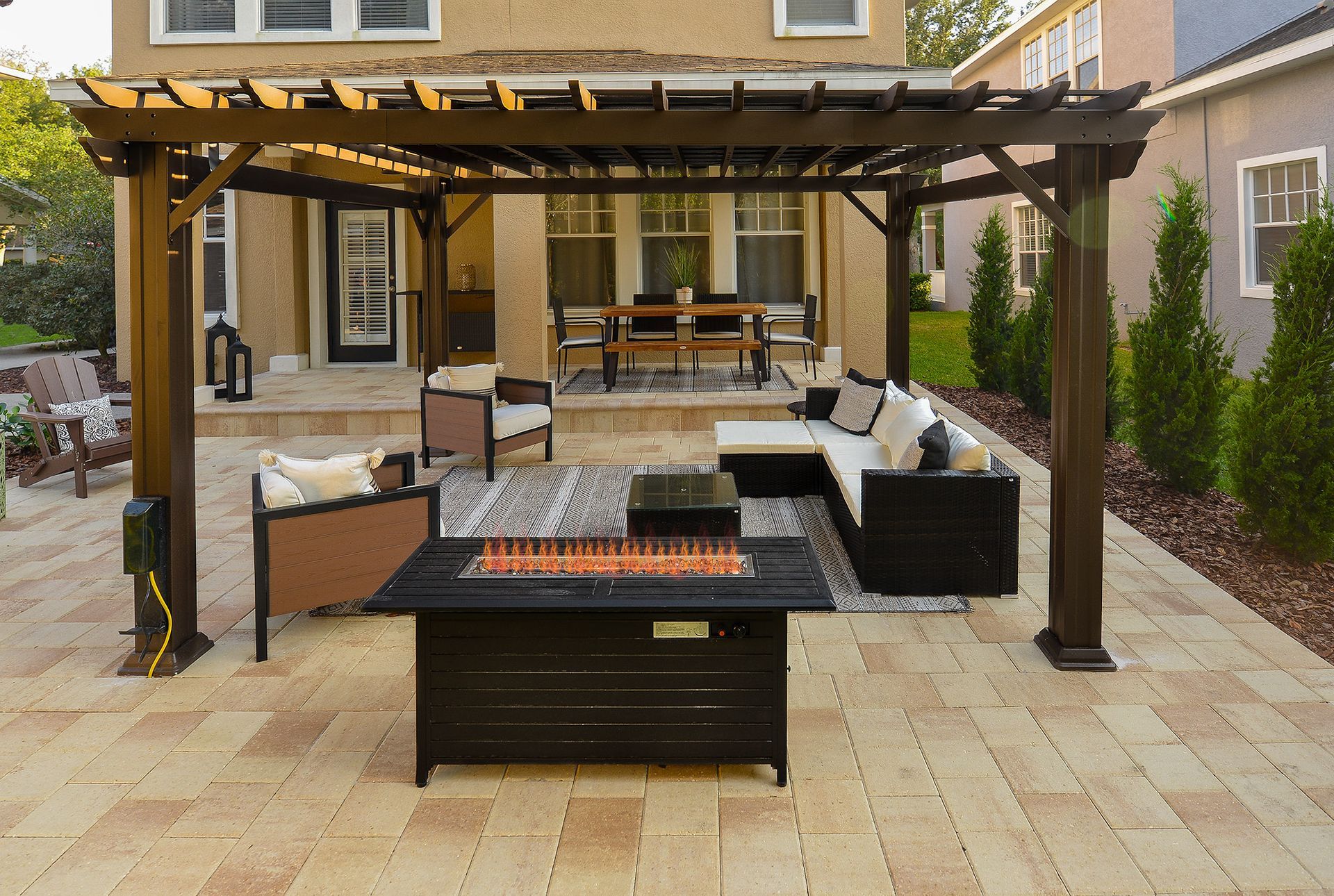 A patio with a pergola and a fire pit