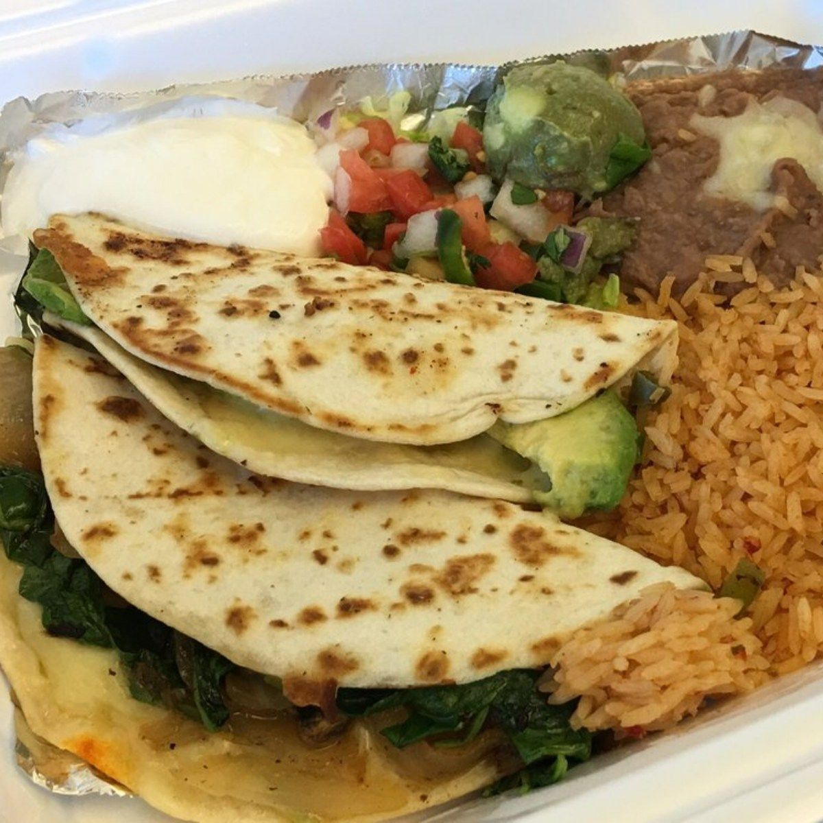 A tray of food with quesadillas rice and beans
